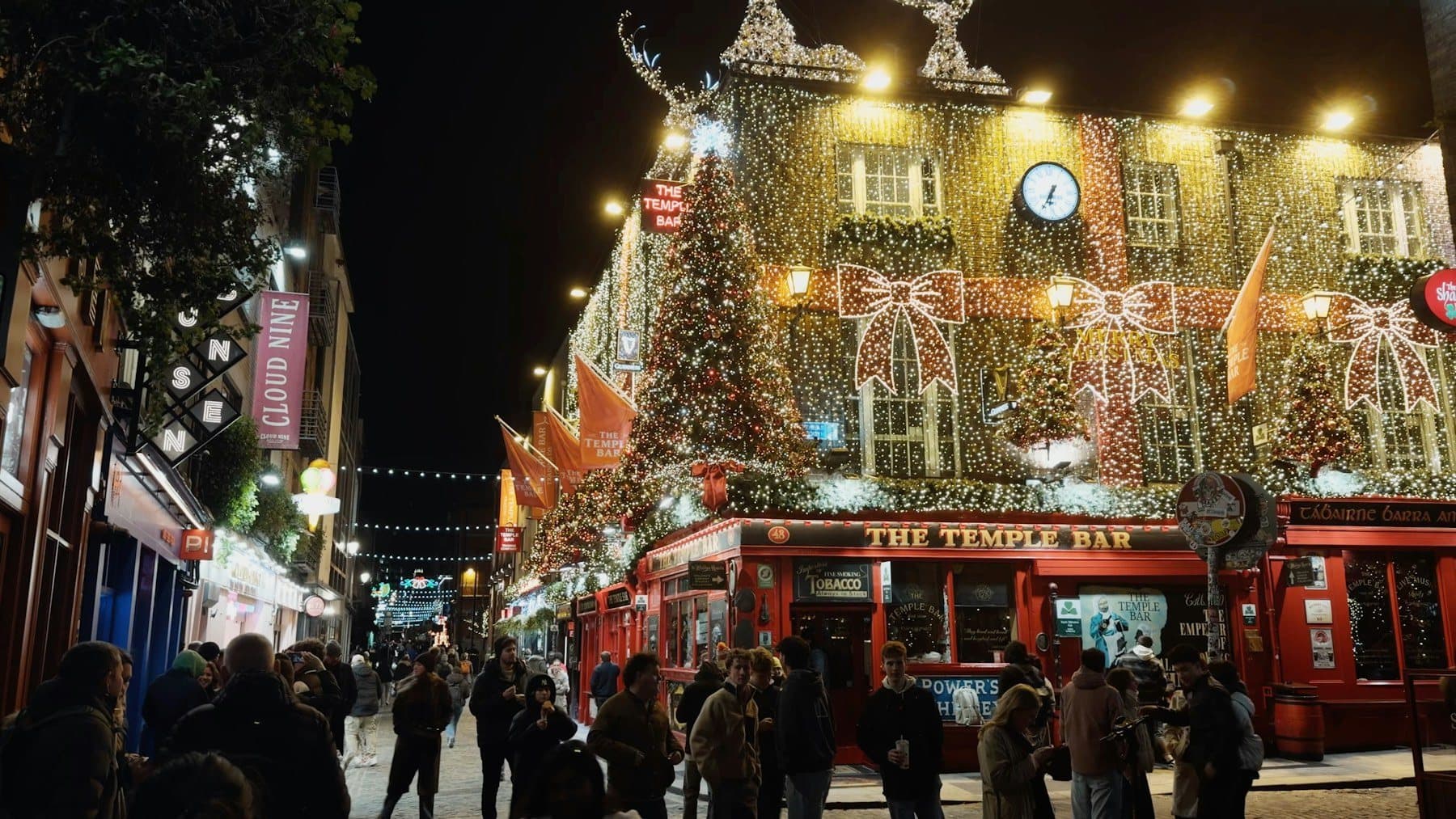 The Temple Bar pub covered in Christmas lights with crowds outside at night
