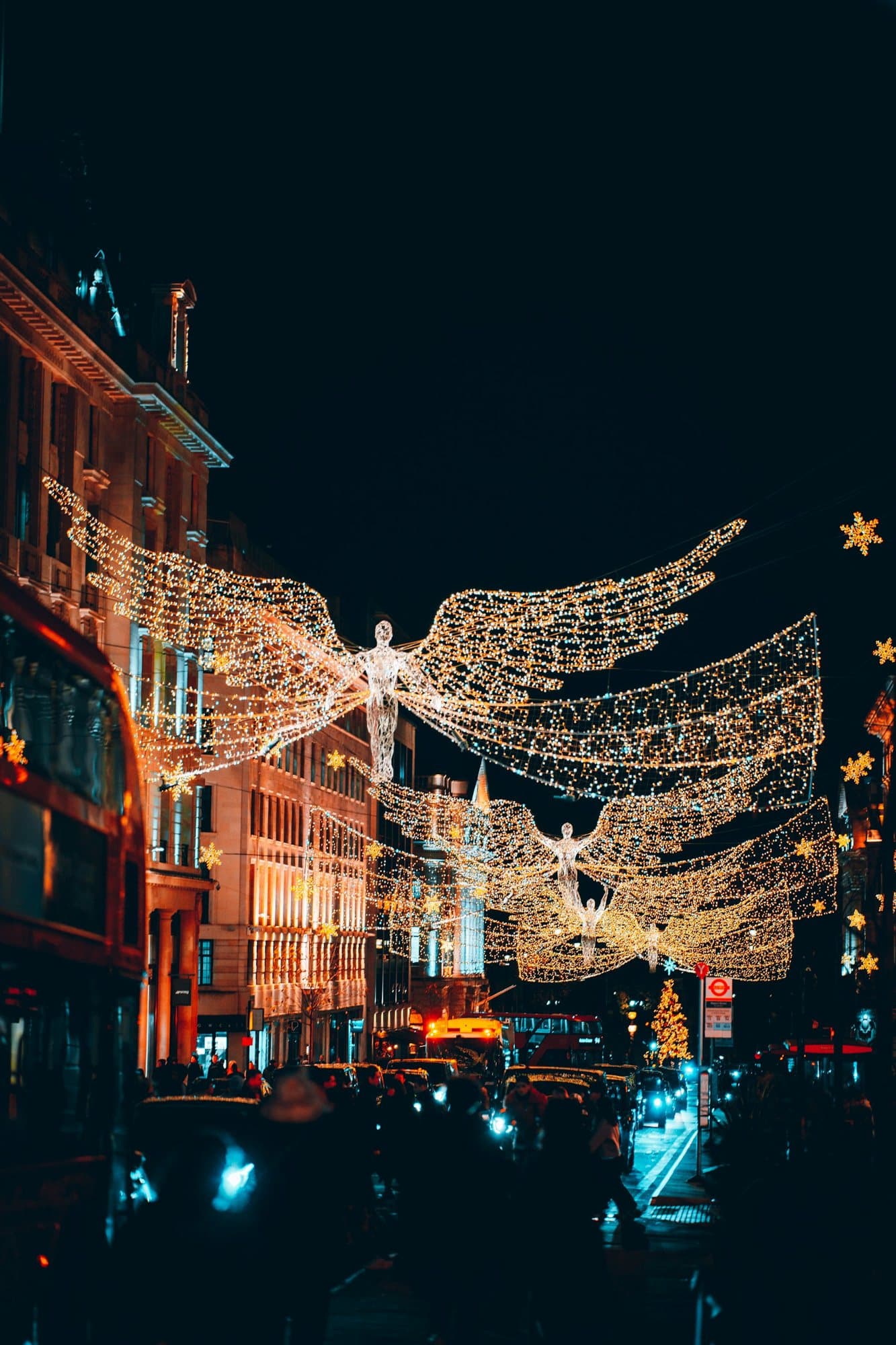 Angel-shaped Christmas lights strung over a Dublin shopping street at night