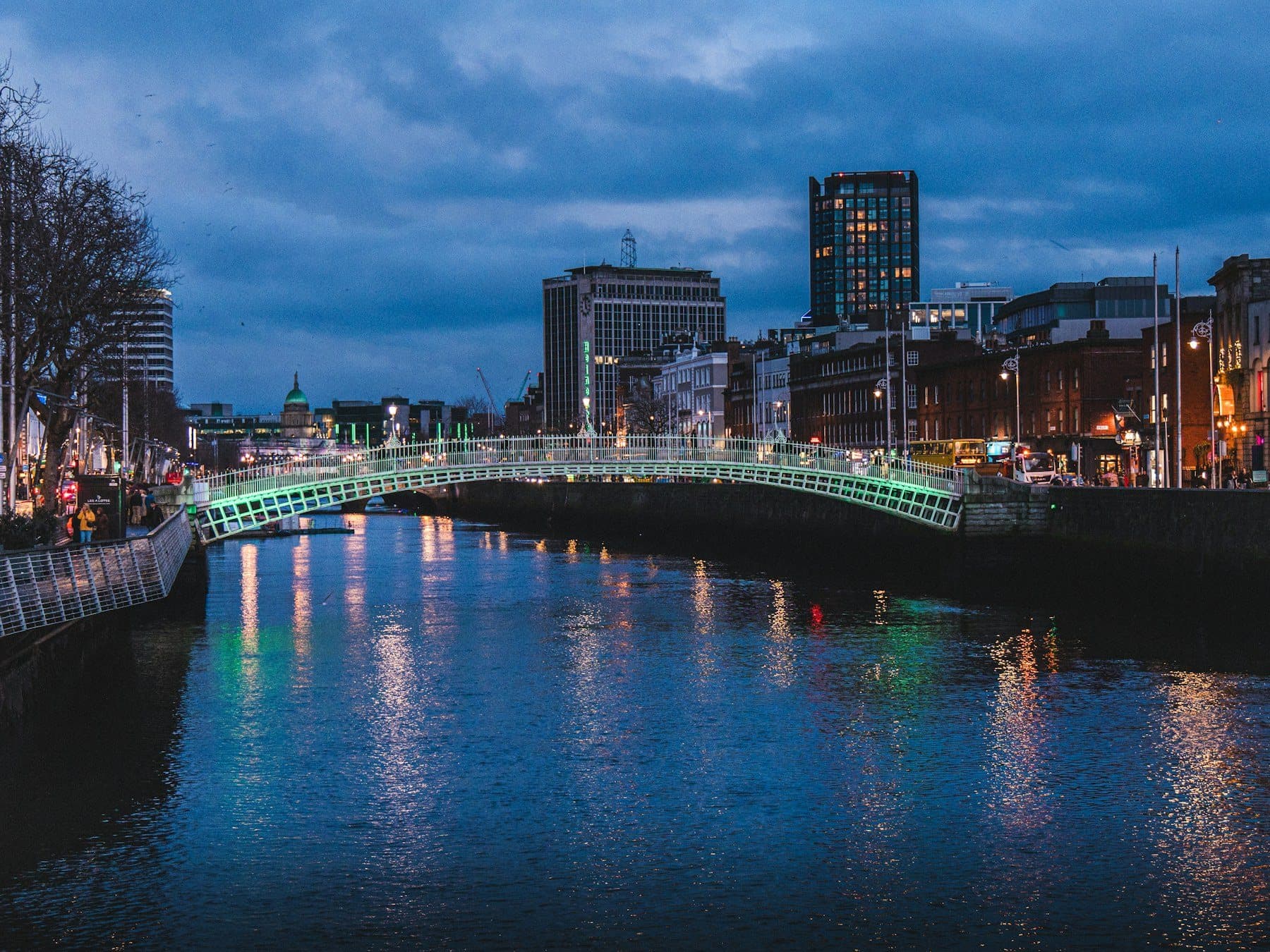 The Ha'penny Bridge lit green over the River Liffey at night